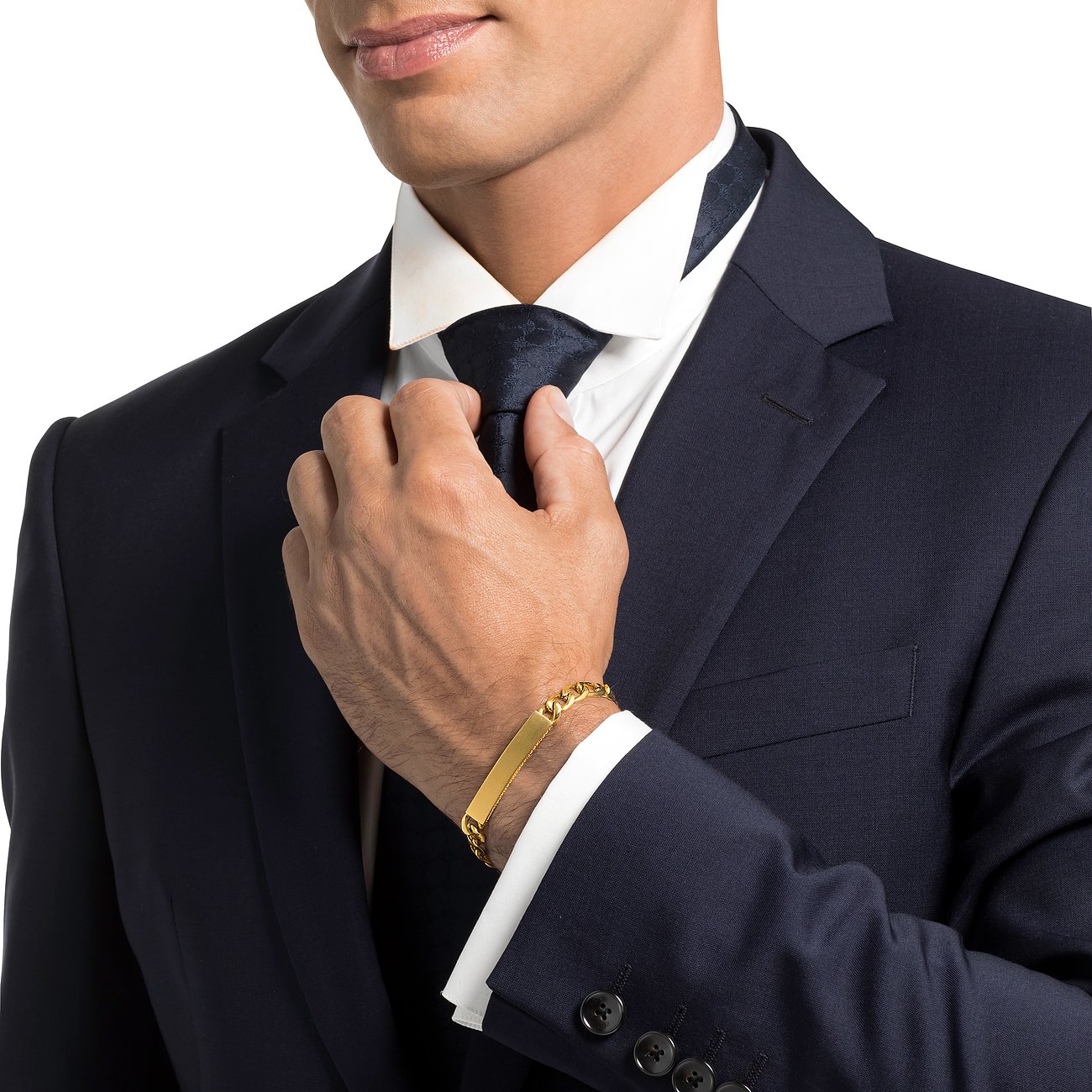 En mand i jakkesæt bærer et gyldent JOOP! armbånd i rustfrit stål med en indgraveringsplade på håndleddet.