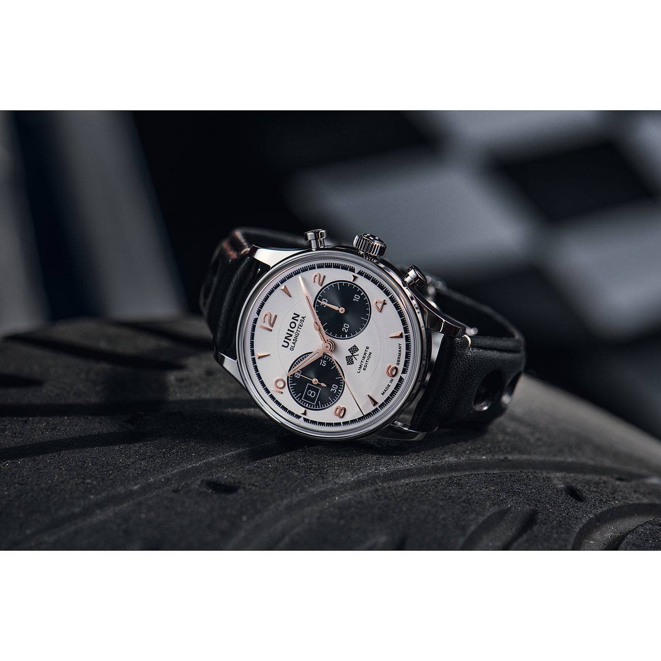 Union Glashütte Chronograph aus Edelstahl mit weißem Zifferblatt und schwarzem Lederband im Profil auf Reifengummi