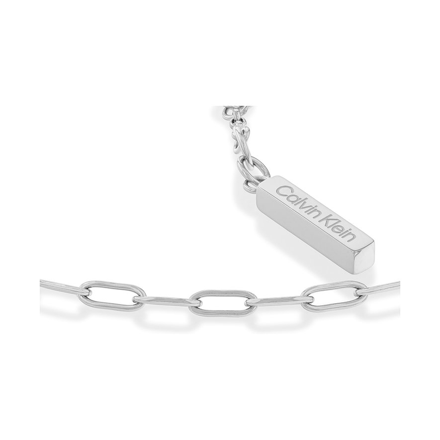 Nahaufnahme eines Calvin Klein Armbands aus Edelstahl mit einer Kette aus ovalen Gliedern und einem gravierten Etikett.