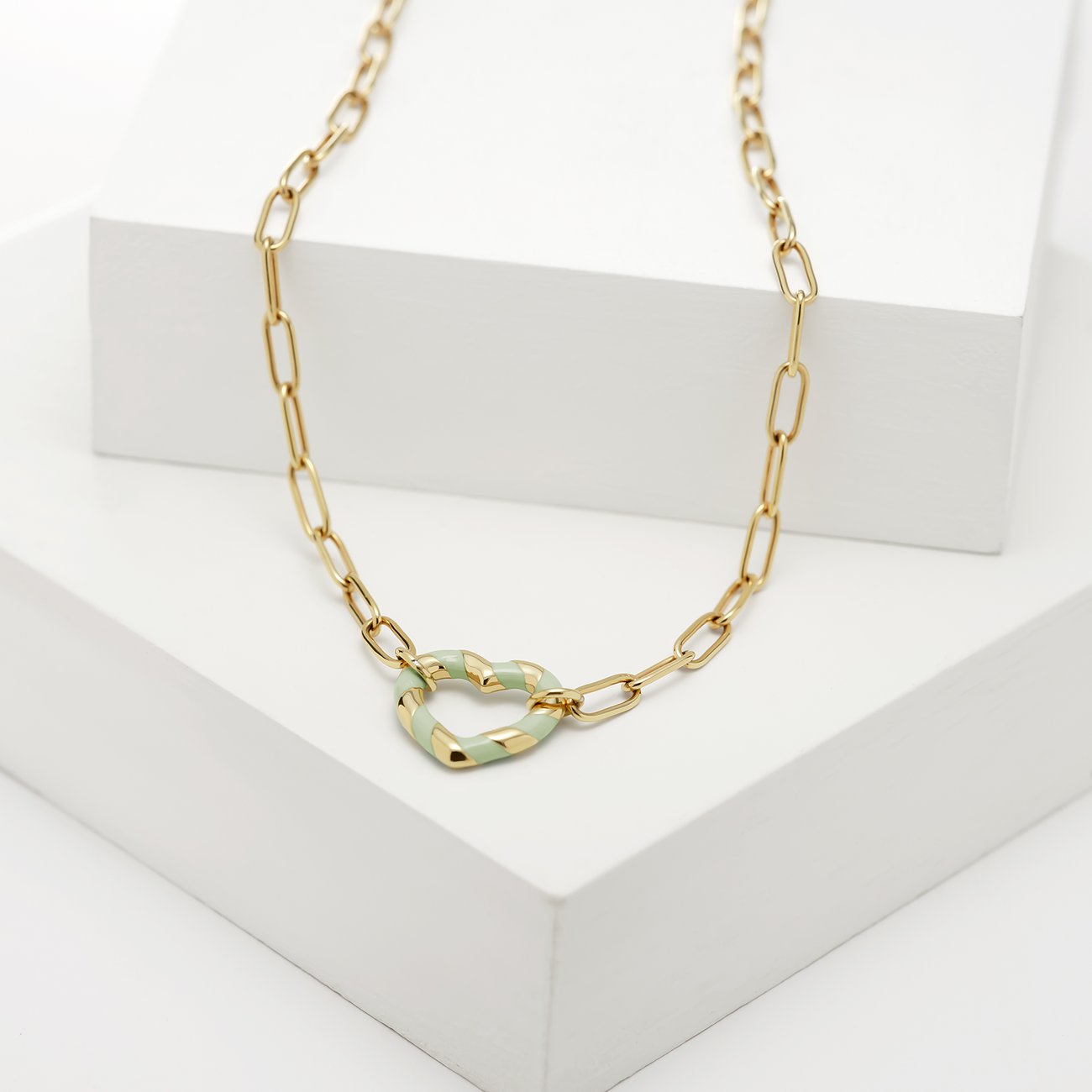 Guido Maria Kretschmer Halskette aus goldfarbenem Edelstahl mit Herzanhänger und mintgrünen Emaille-Streifen.