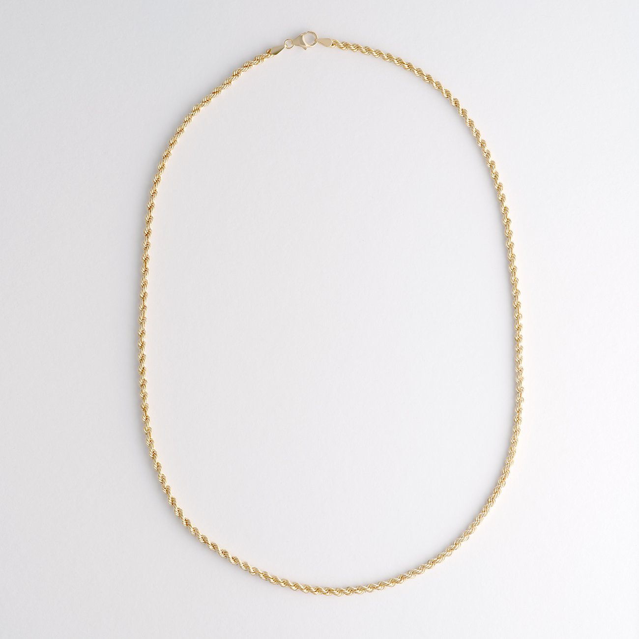 FAVS 375er Gelbgold-Halsschmuck als filigrane Kette mit Kordelgeflecht und Karabinerverschluss, von oben aufgenommen.