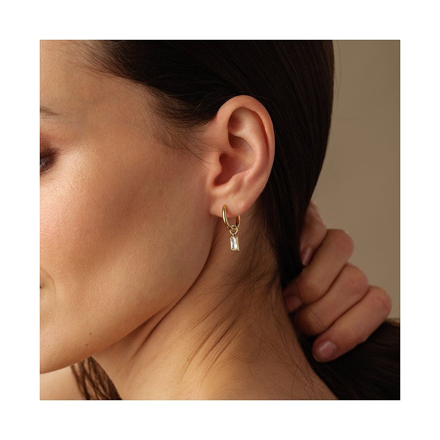 FAVS Ohrschmuck aus gelbvergoldetem Edelstahl mit hängendem Baguette-Zirkonia, getragen am Ohr einer Frau.