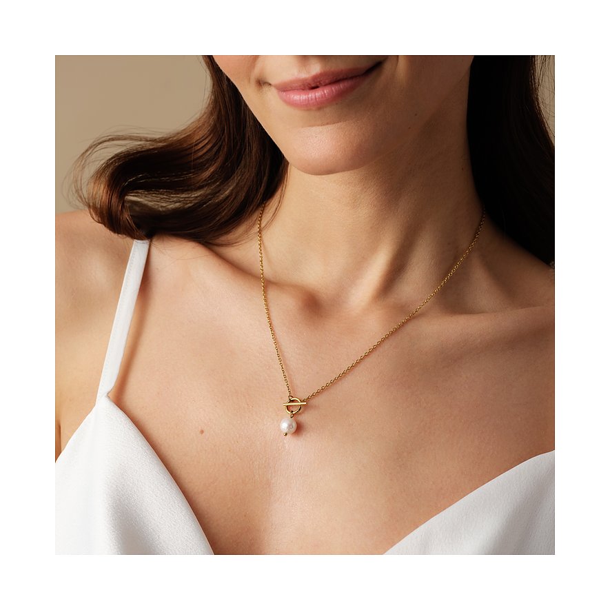 Een vrouw draagt een glamoureuze FAVS ketting van goudkleurig roestvrij staal met T-sluiting en een parel.
