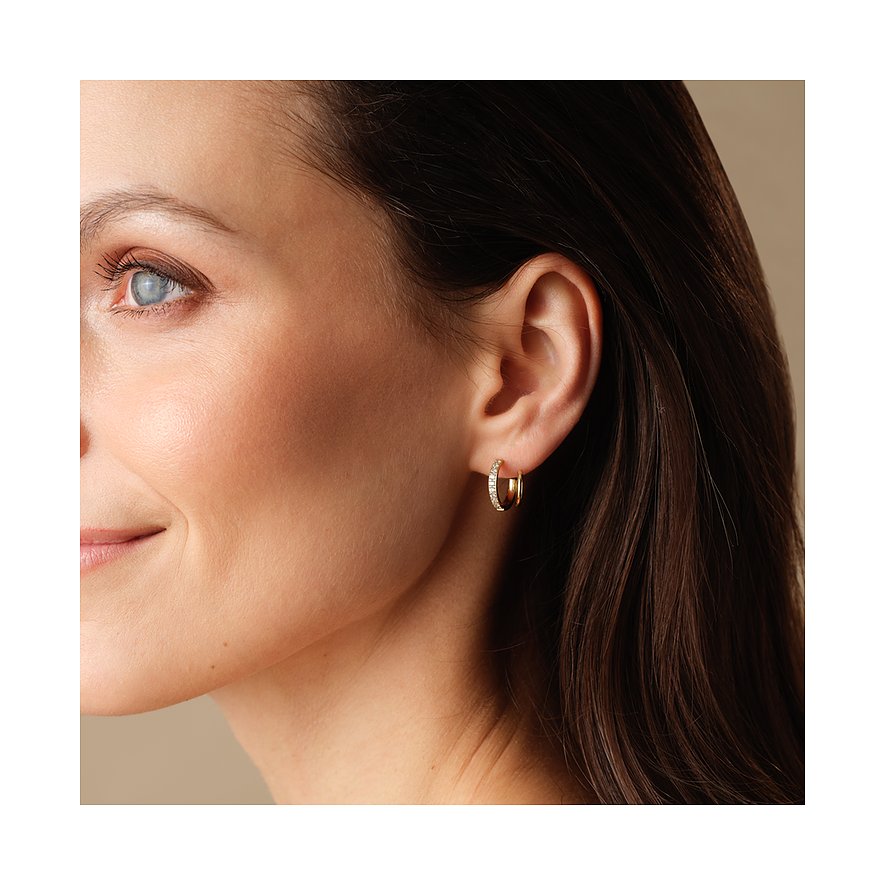 Een vrouw draagt een FAVS creool oorbel van goudkleurig roestvrij staal met zirkonia stenen.