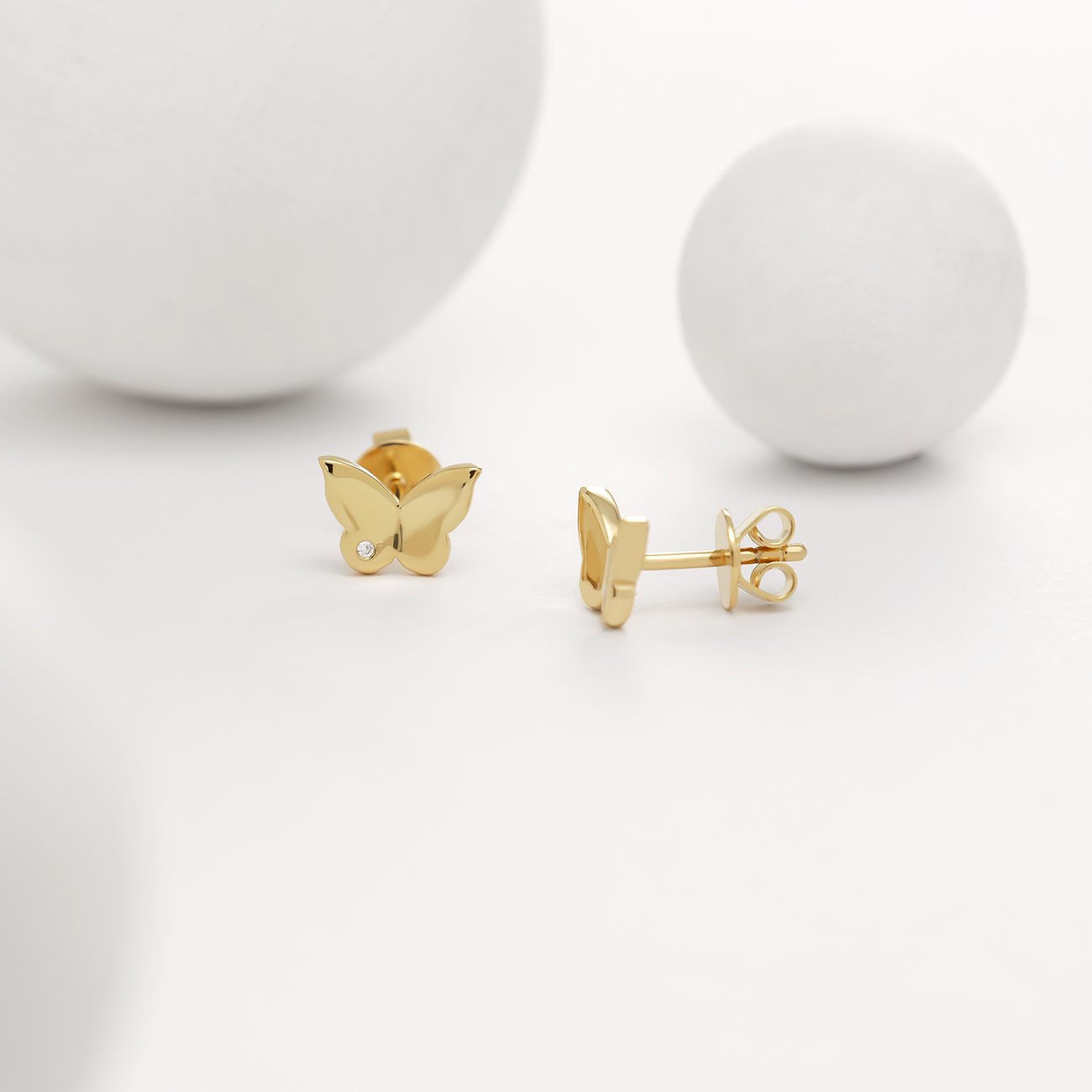 Guido Maria Kretschmer Ohrstecker in Schmetterlingsform aus goldfarbenem Silber mit einem Diamant.