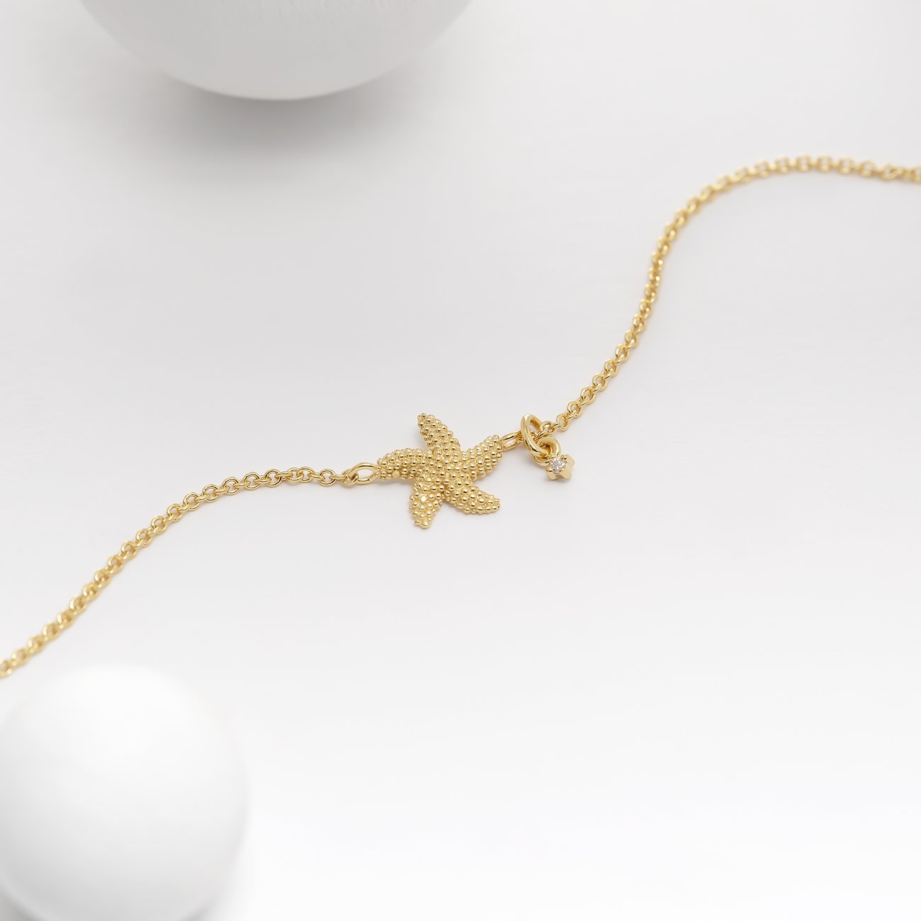 Guido Maria Kretschmer Armband aus goldfarbenem 925er Silber mit strukturiertem Seestern und kleinem Diamanten.