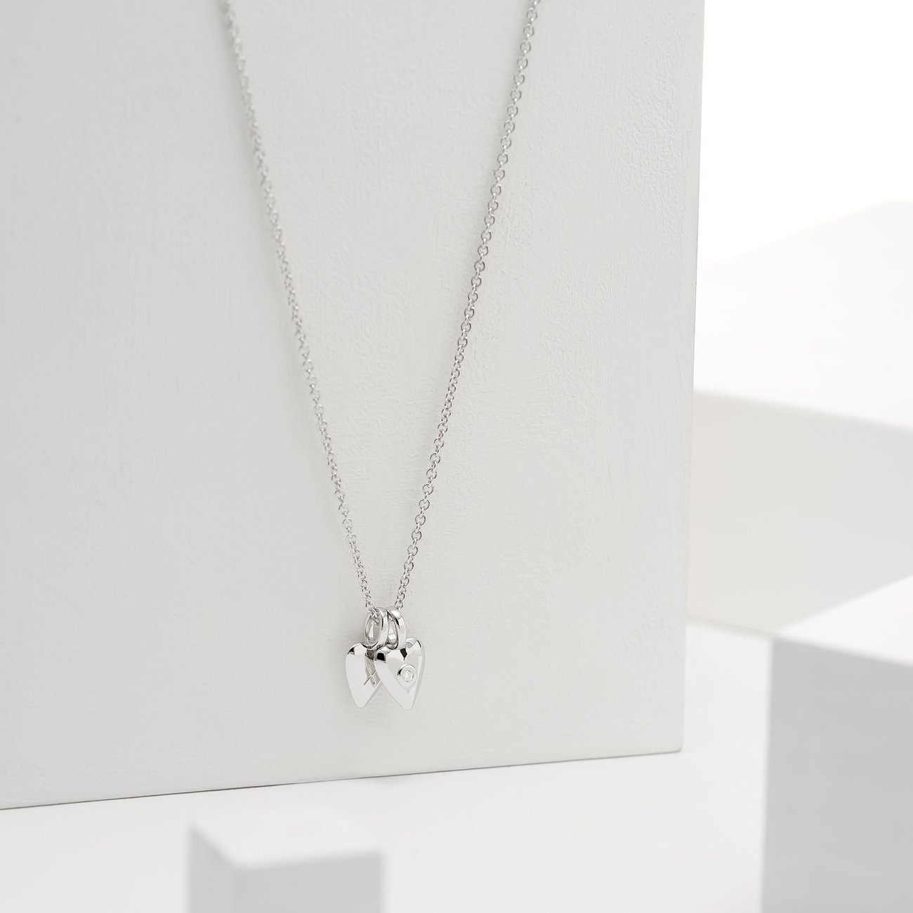 Guido Maria Kretschmer silverhalsband med diamant-hjärtformade hängen som elegant dinglar.