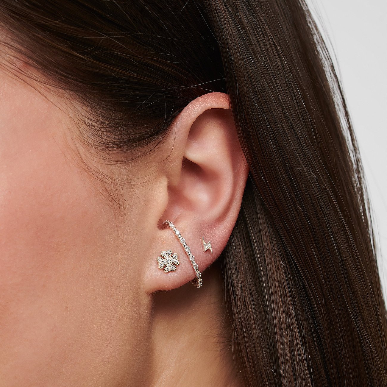 Thomas Sabo Ohrringe aus 925er Silber mit weißen Zirkonia in Blumen- und Blitzform.