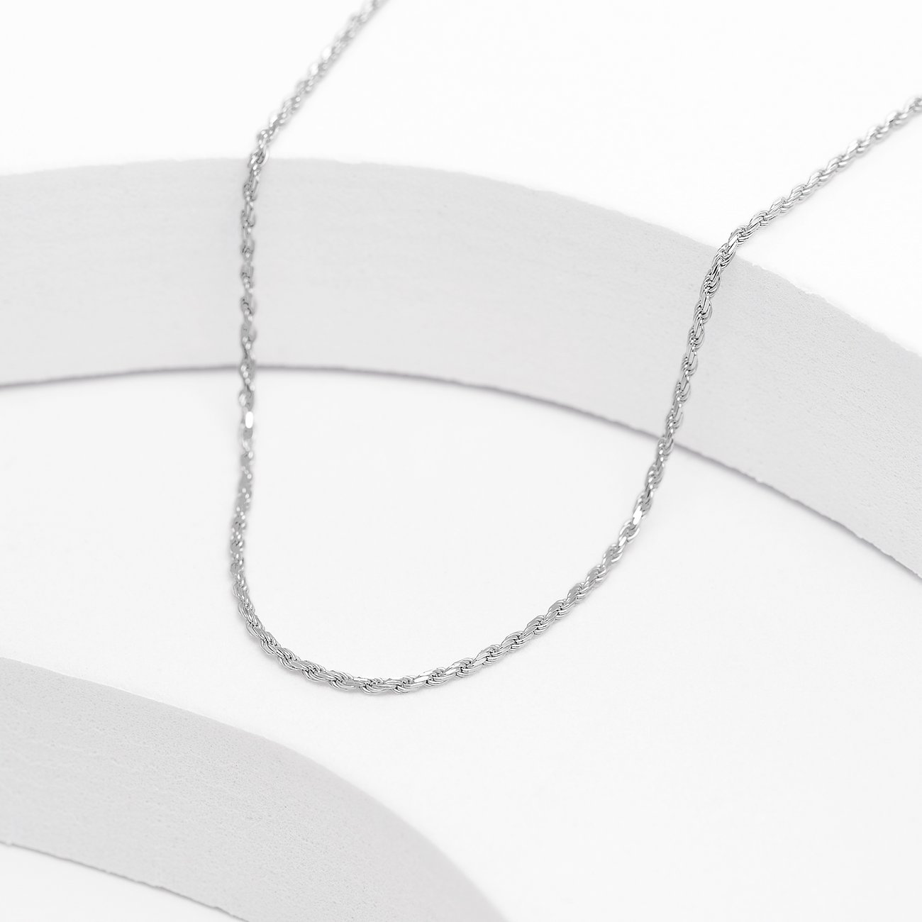 Recycelte, gedrehte Halskette aus 925er Silber auf einem weißen Hintergrundband.