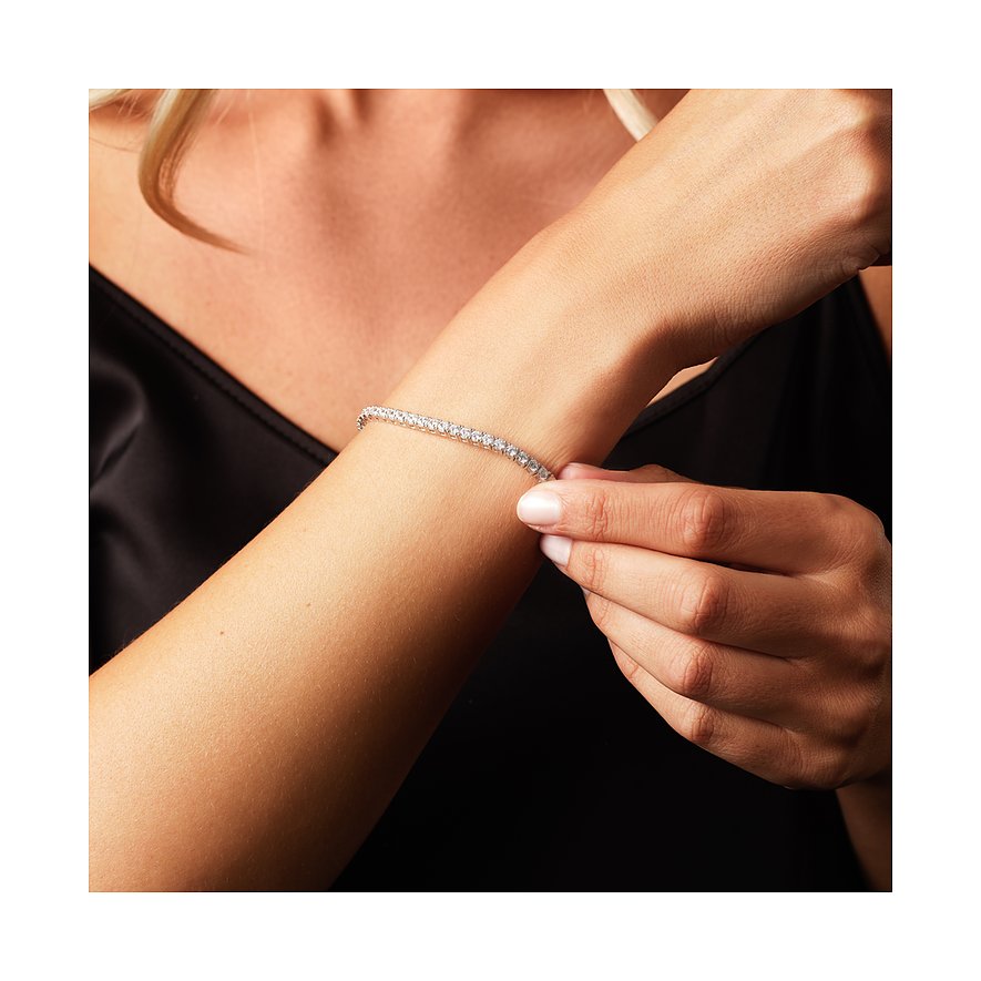 Eng anliegender Tennisschmuck Armreif aus recyceltem 925er Silber mit funkelnden Zirkonia-Steinen am Handgelenk einer Frau.
