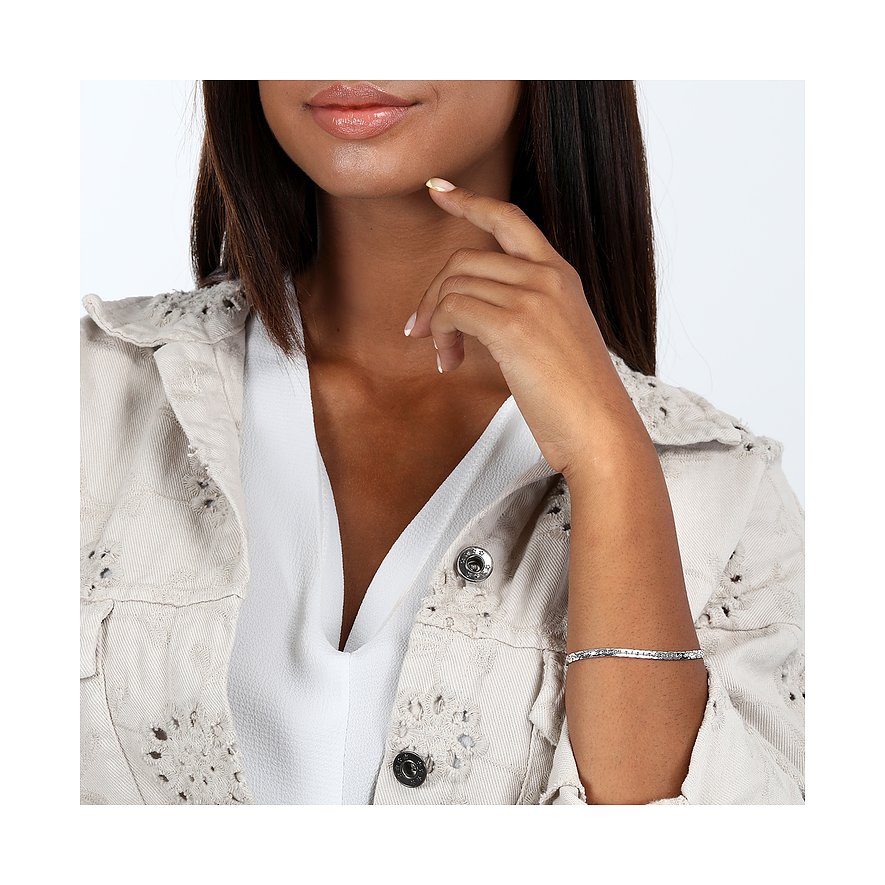 Ett CHRIST armband i 375 vitguld på en arm, buret av en person i beige jacka.