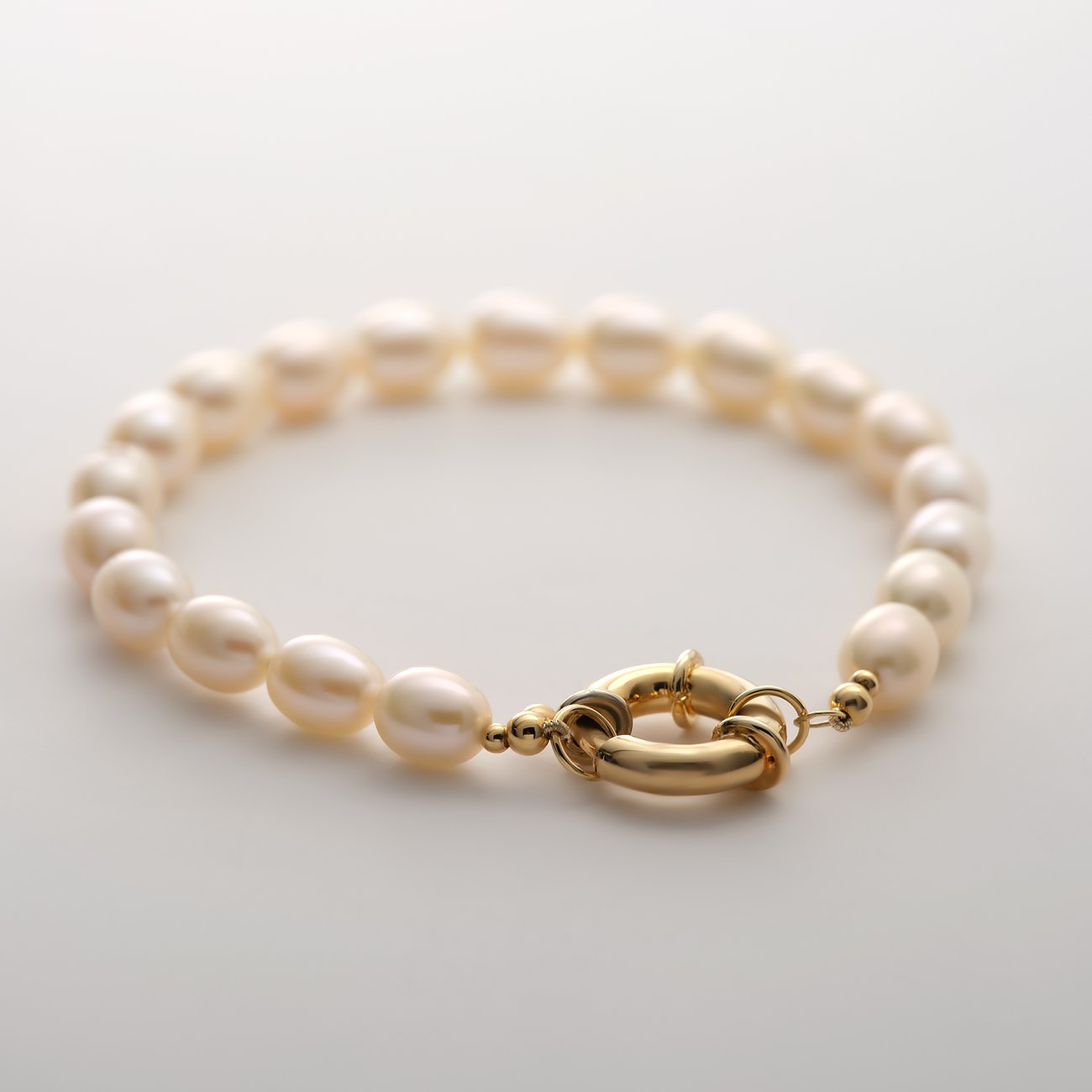 Bracelet YAMOKO en or jaune 585 avec perles ovales et fermoir rond, sur fond clair.