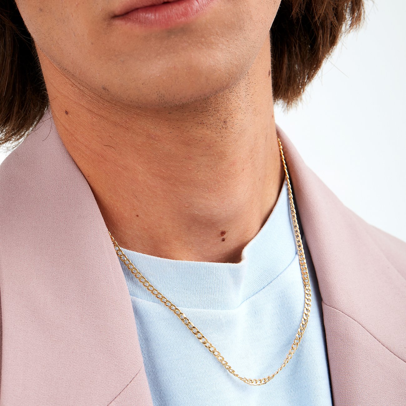 Close-up van een man met een goudkleurige CHRIST schakelketting van 375 geelgoud om zijn nek.
