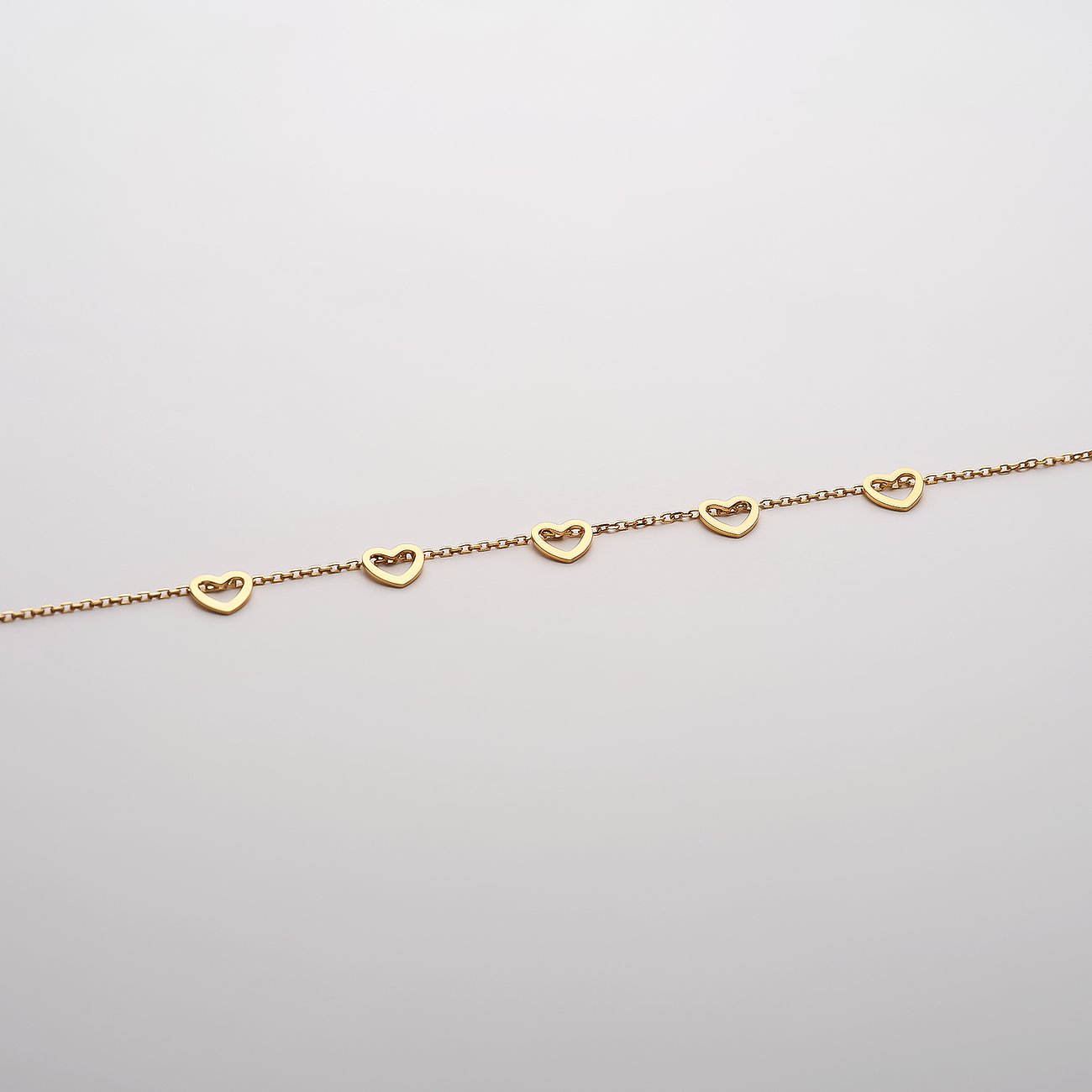 CHRIST Armschmuck aus 585er Gelbgold mit fünf herzförmigen Elementen auf einer feinen Kette.