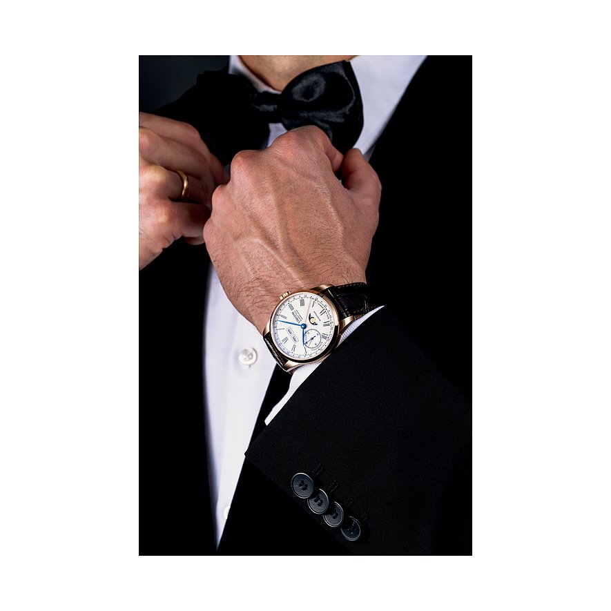 Ein Mann im Anzug bindet sich eine Fliege, am Handgelenk trägt er eine Union Glashütte Herrenuhr aus Roségold.