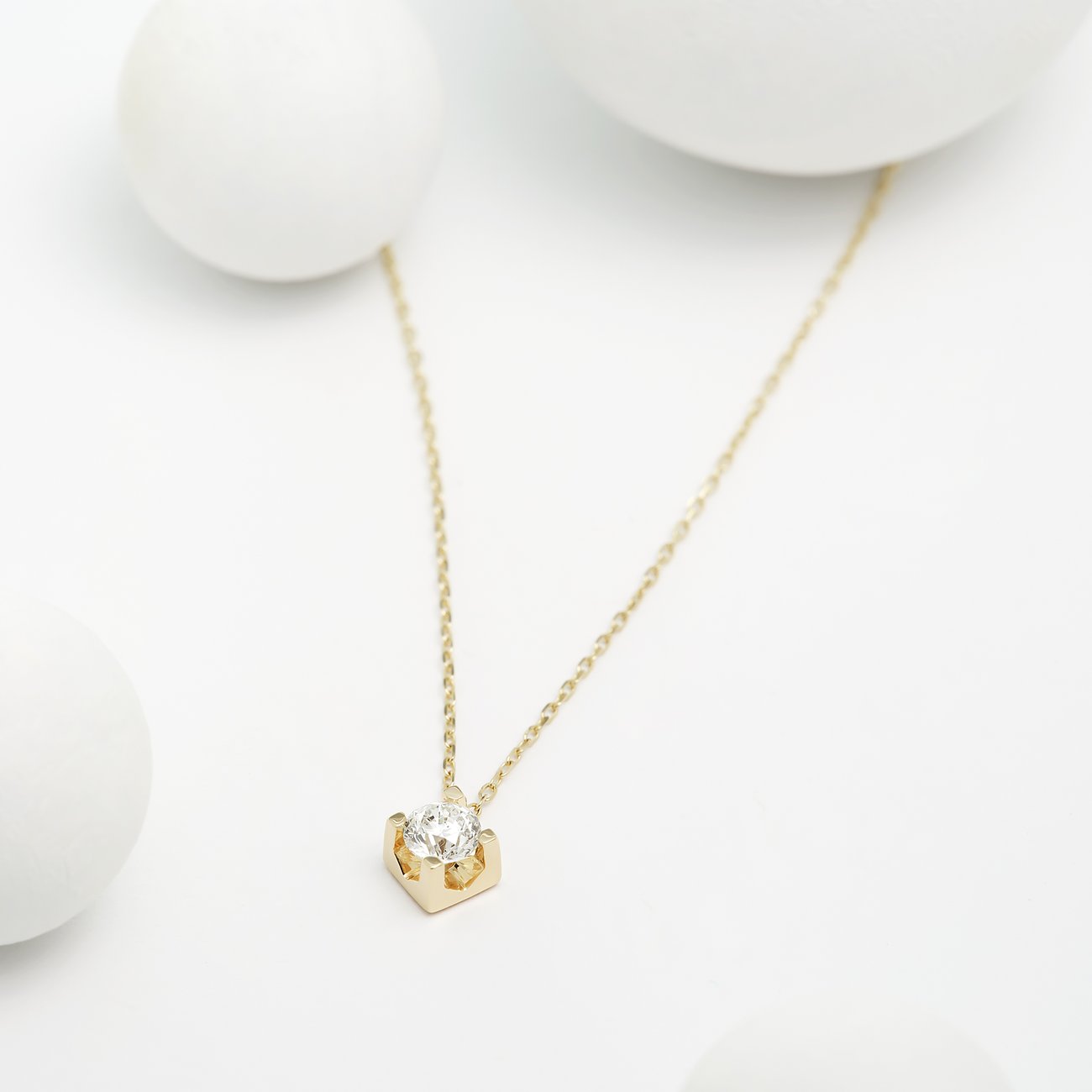 CHRIST Halsschmuck aus Gelbgold zeigt einen Einzel-Diamanten in einer markanten Krappenfassung gegen weißen Kugeln.