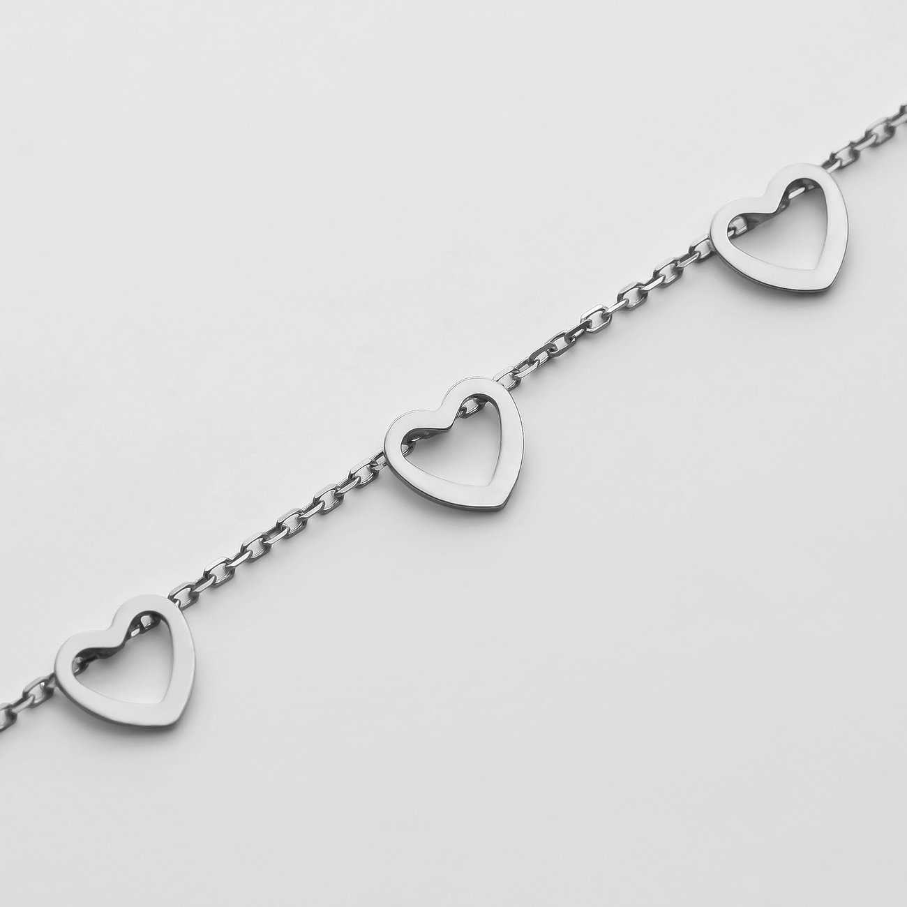 CHRIST 585 Weißgold Armband: Filigrane Kette mit drei hohlen Herzanhängern, links, mittig und rechts angebracht.