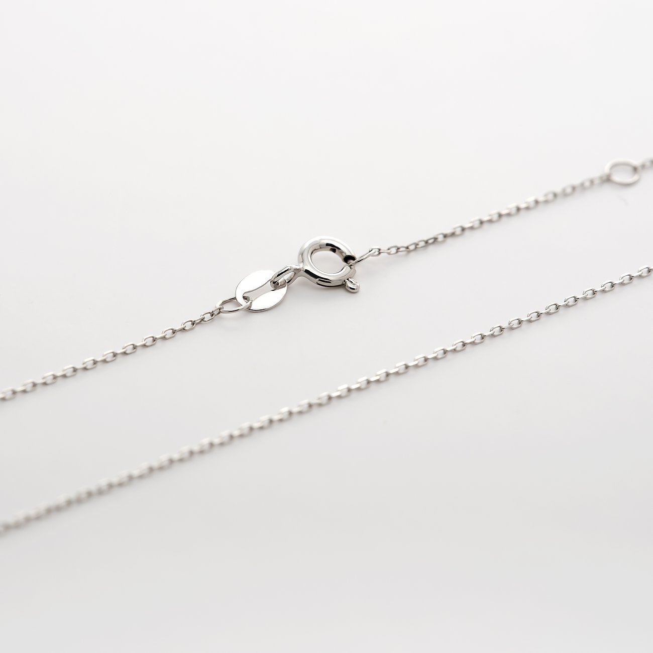 Närbild av CHRIST 585 vitgulds-halsband, som visar låset och en del av kedjan.