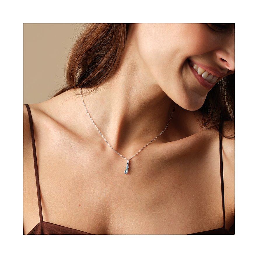 FAVS 925 sterlingsilverhalsband med tre blå zirkoner, buret av en kvinna.