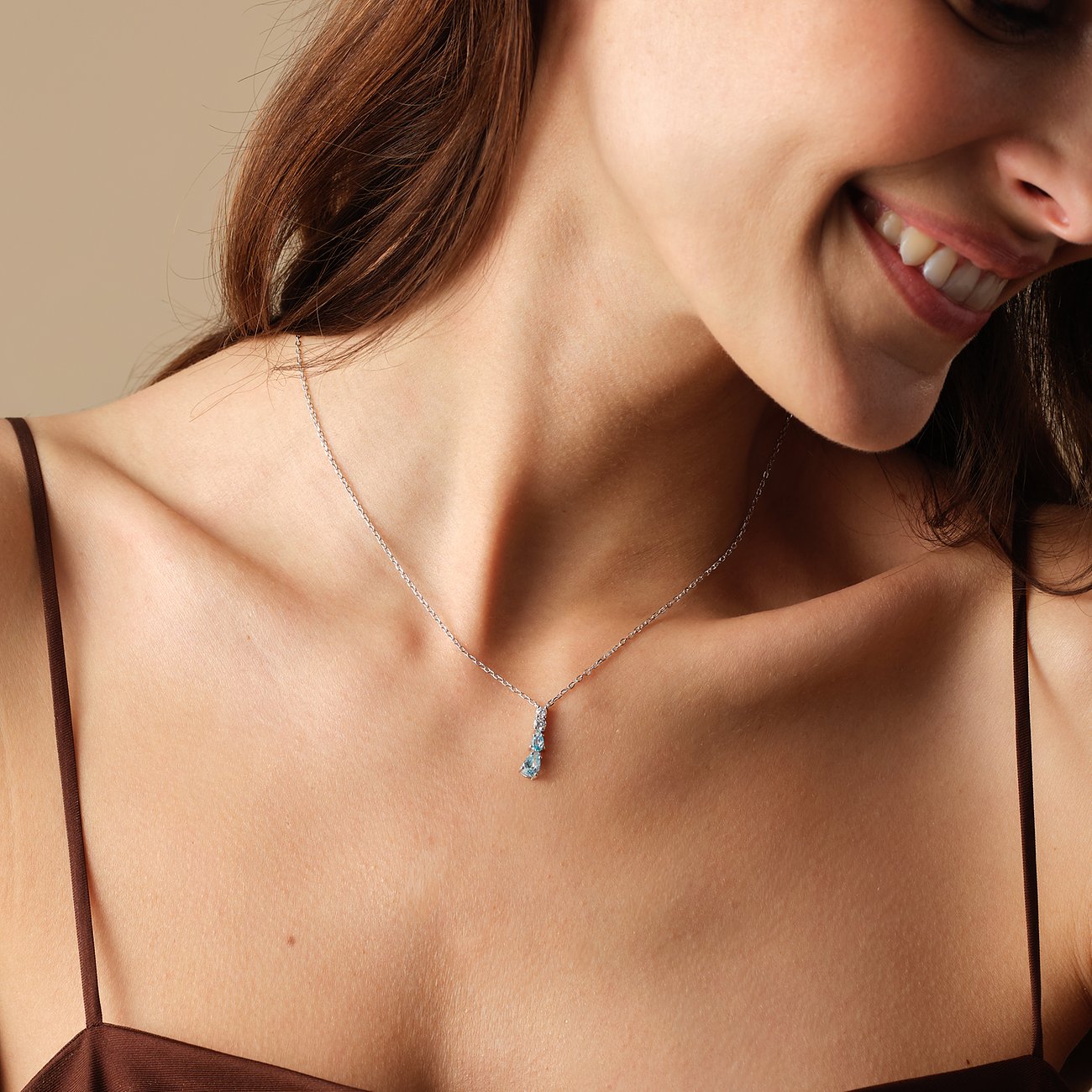 FAVS 925 sterlingsilverhalsband med tre blå zirkoner, buret av en kvinna.