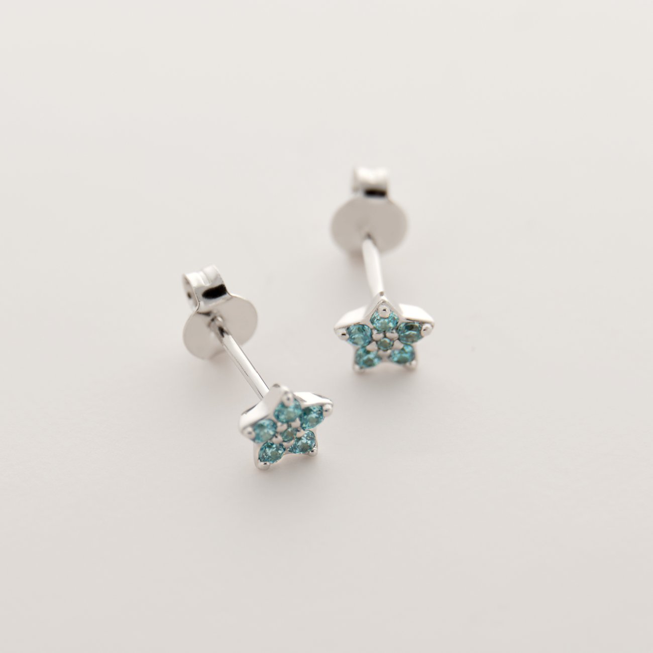 FAVS Little Friends oorknopjes van 925 zilver met blauwe zirkonia sterren, van dichtbij gefotografeerd.