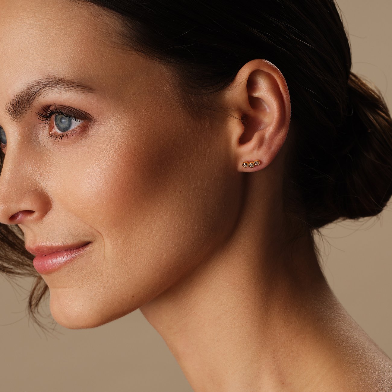 FAVS Ohrstecker aus vergoldetem 925er Silber mit Zirkonia-Steinen, am Ohr einer Frau getragen, Seitenansicht.