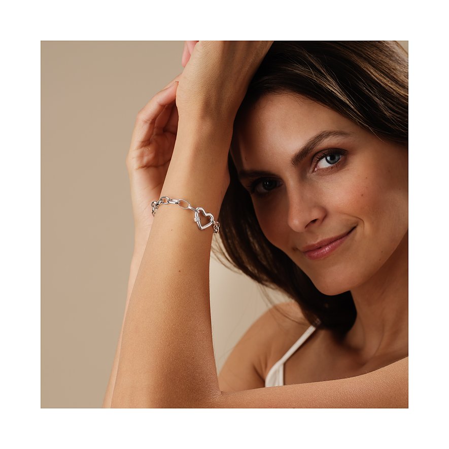Gros plan d'une femme portant un bracelet CHRIST en forme de cœur, en argent recyclé avec des accents de zircon.