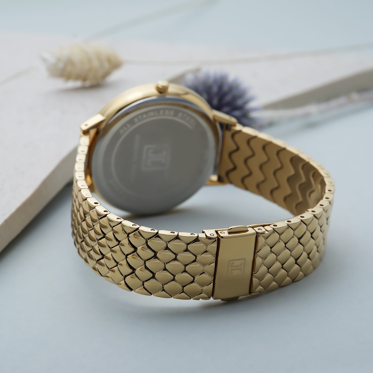 JETTE Damenuhr aus Edelstahl, goldfarben, mit Kristallen und Schuppenmuster.