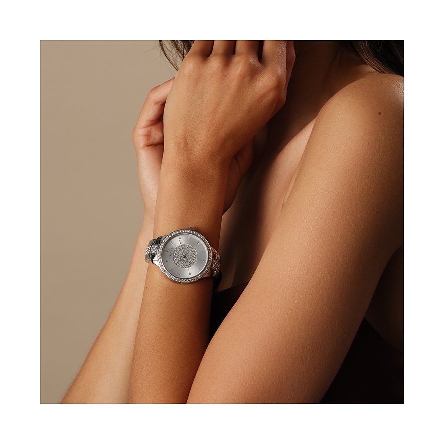 Am Handgelenk einer Frau ist eine JETTE Damenuhr aus Edelstahl mit einem Besatz aus Kristallen in Nahaufnahme zu sehen.