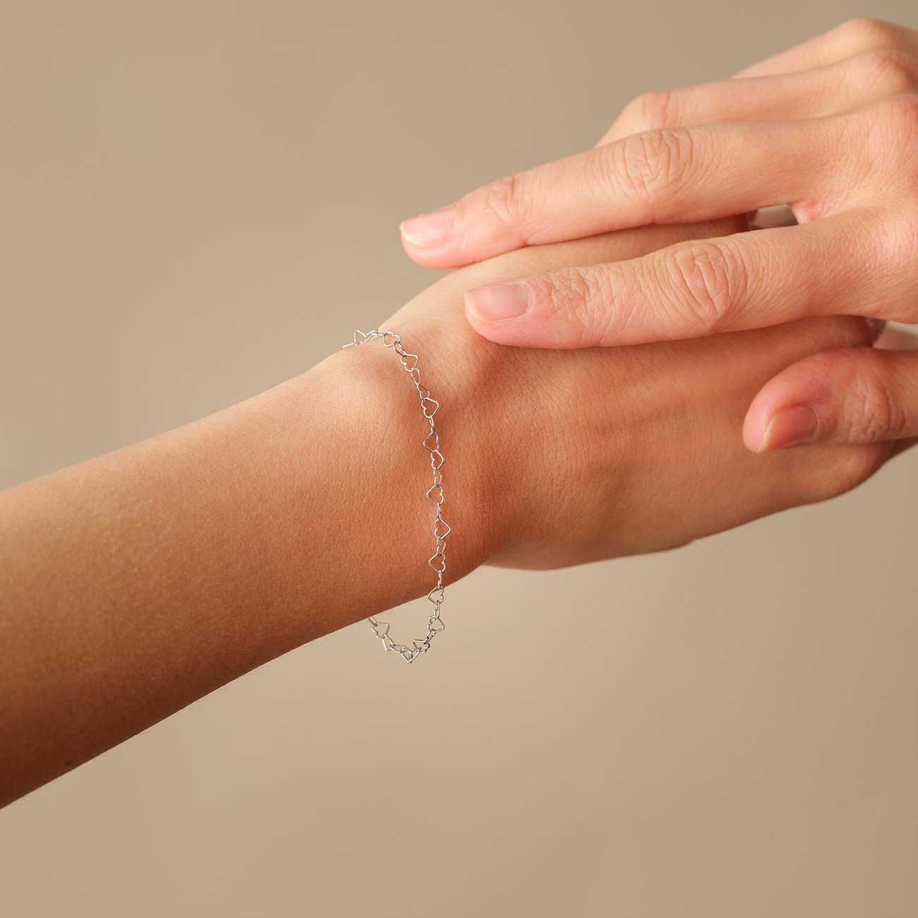 FAVS Armschmuck aus recyceltem 925er Silber von oben an einem Handgelenk mit Herzen.