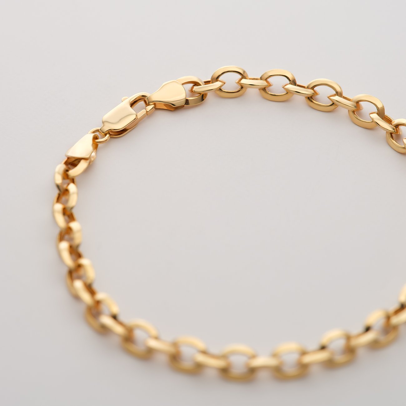 Nahaufnahme eines CHRIST 585 Gelbgold Armbands in Schlangenkette mit Karabinerverschluss auf weißem Hintergrund.