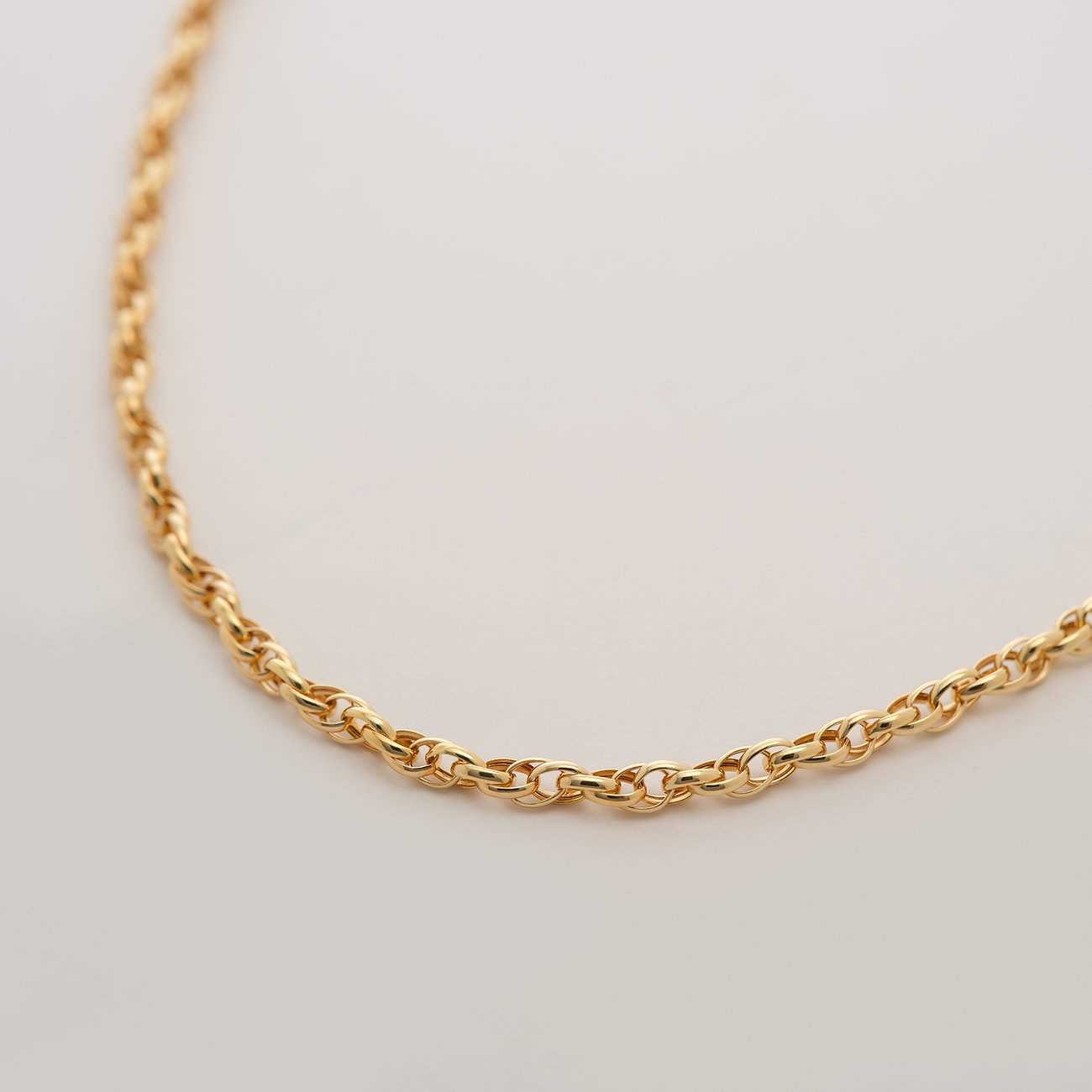 Nahaufnahme einer CHRIST Rundanker Goldkette aus 585er Gelbgold, leicht geschwungen von links oben nach rechts unten.