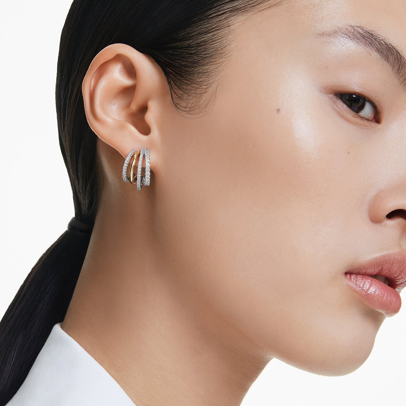 Swarovski metalen oorbellen met witte kristallen en gouden elementen.