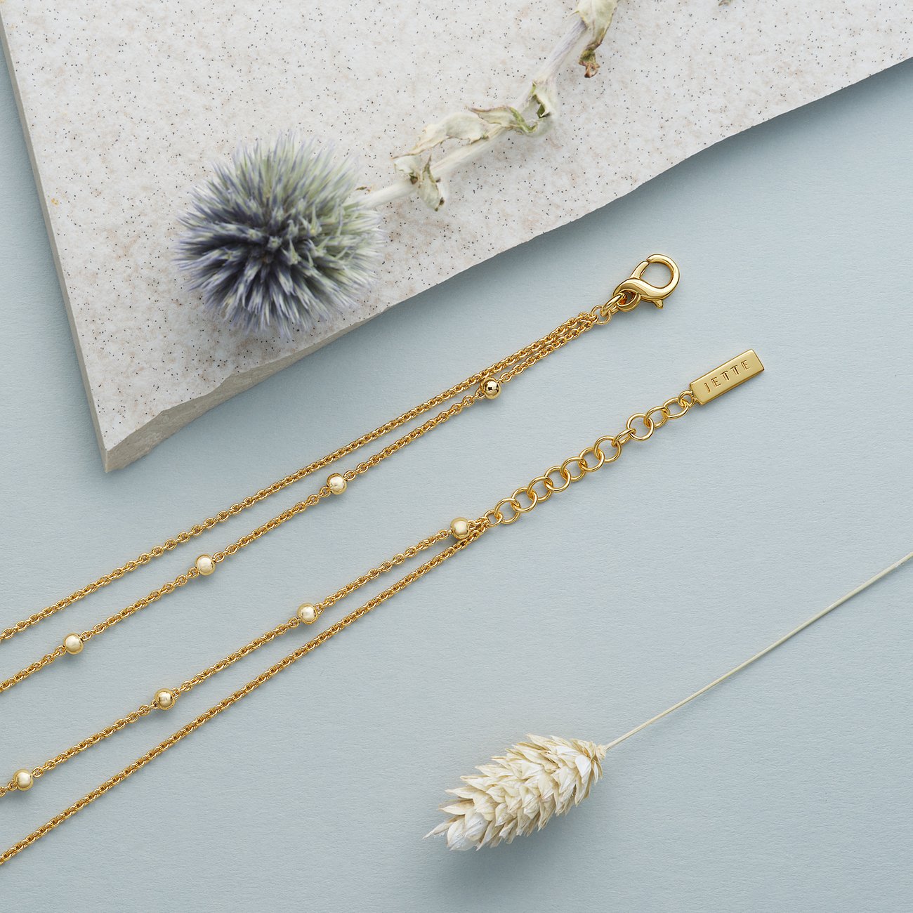 Nahaufnahme einer zweireihigen, goldfarbenen JETTE Halskette aus recyceltem Silber mit kleinen Kugeln.