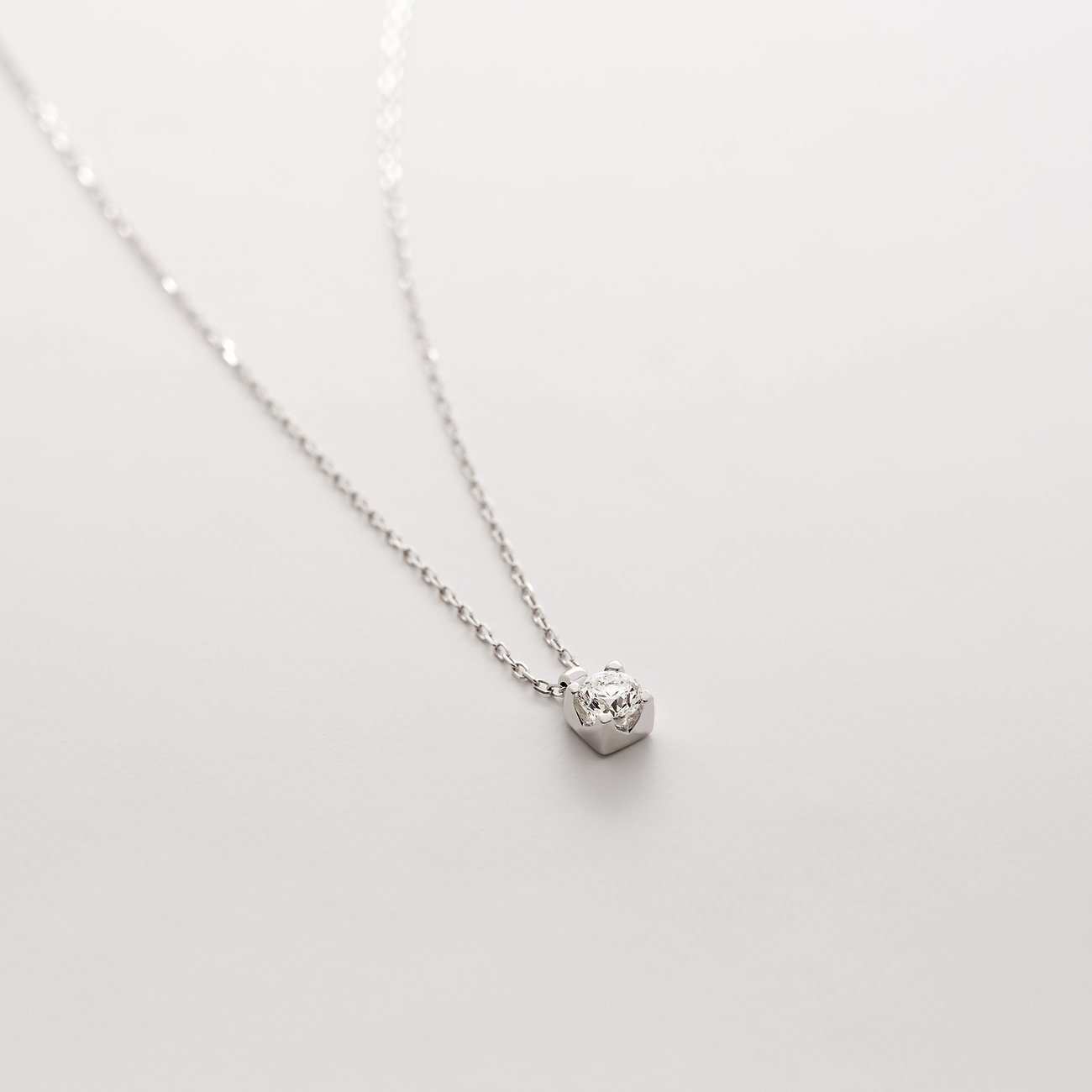 Nahaufnahme einer zarten CHRIST Halskette aus 585er Weißgold, besetzt mit einem glänzenden Diamanten.