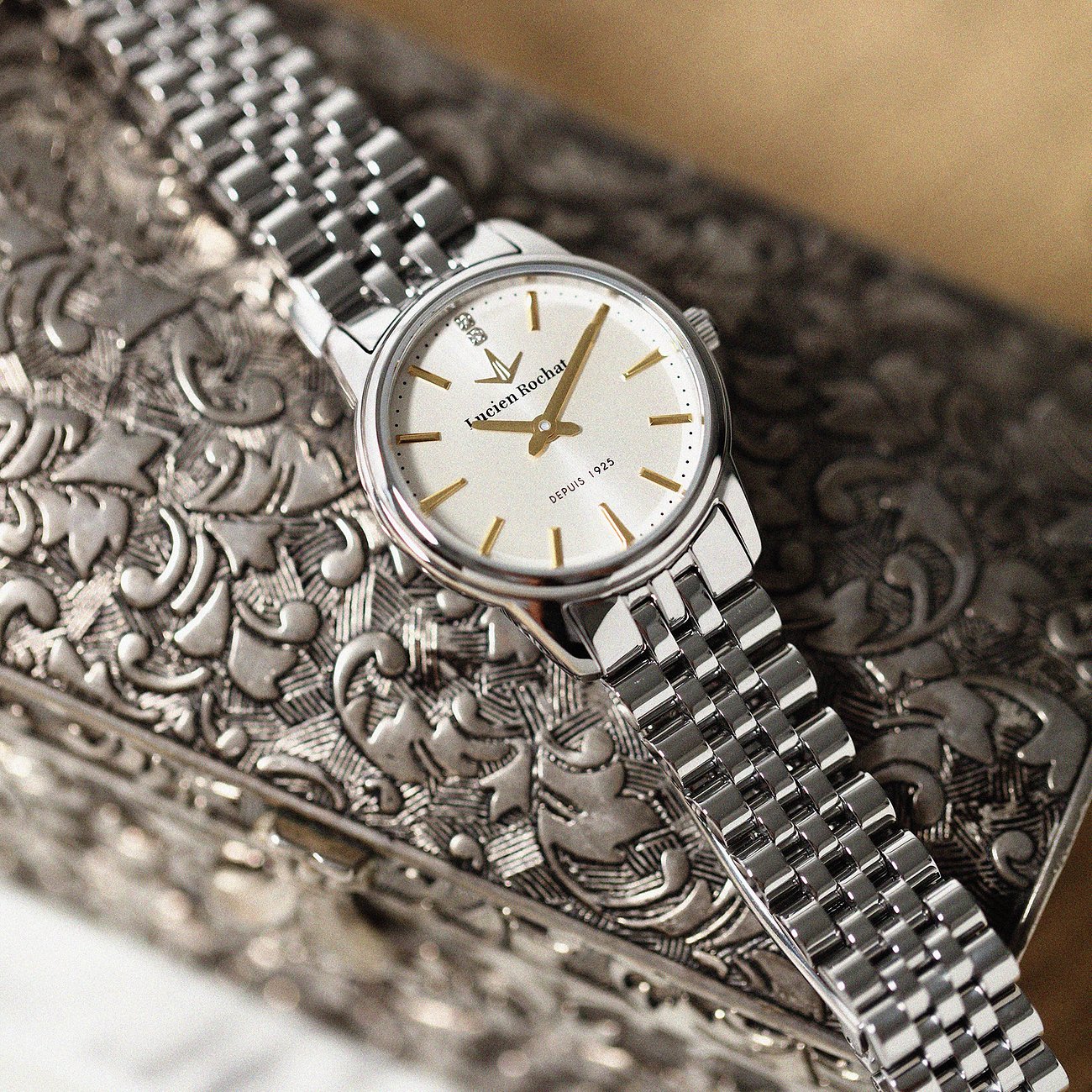 Primo piano di un orologio da donna Lucien Rochat in acciaio inossidabile con diamanti e quadrante bianco.