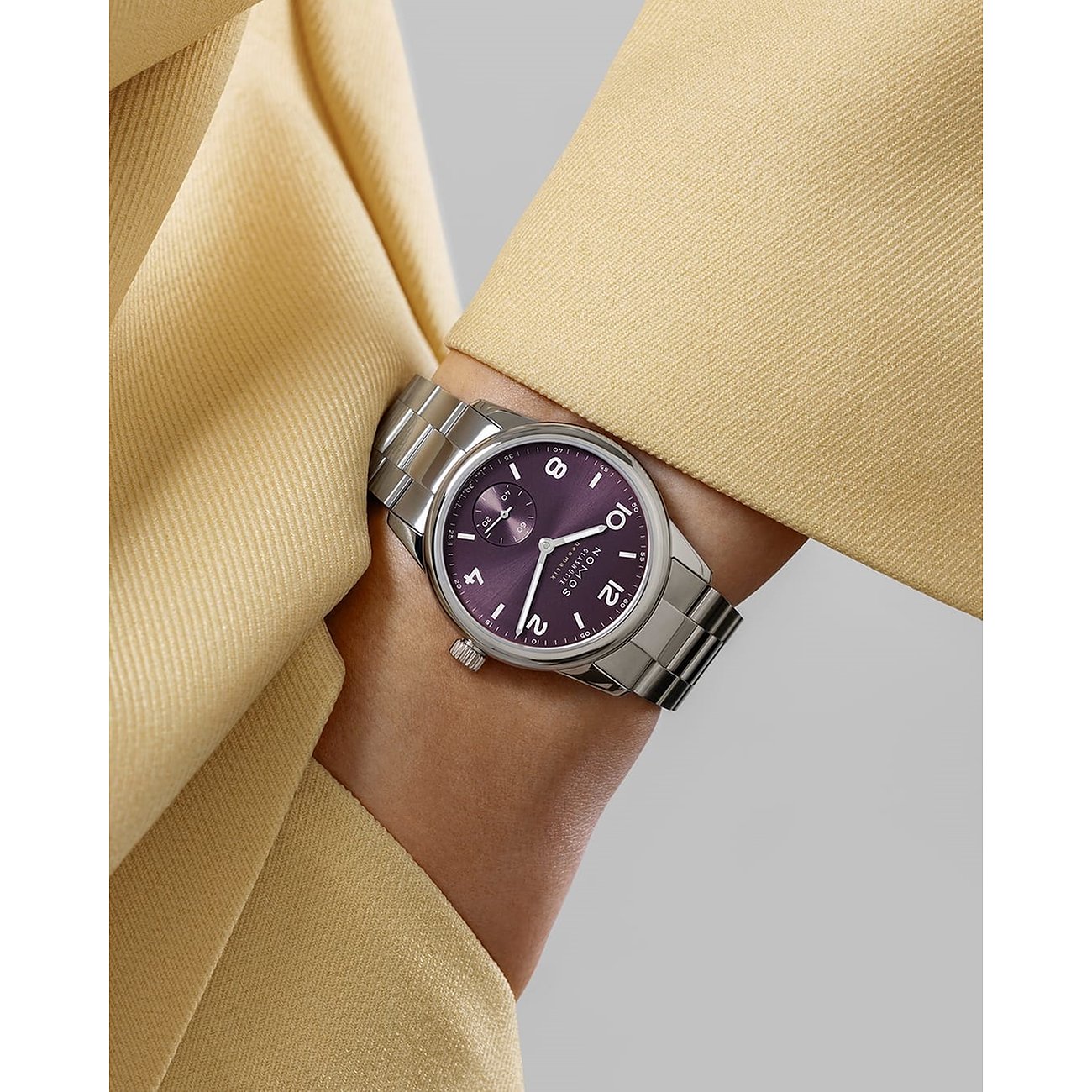 Nomos Glashütte Damenuhr mit Edelstahlgehäuse, lila Zifferblatt und silbernem Armband.