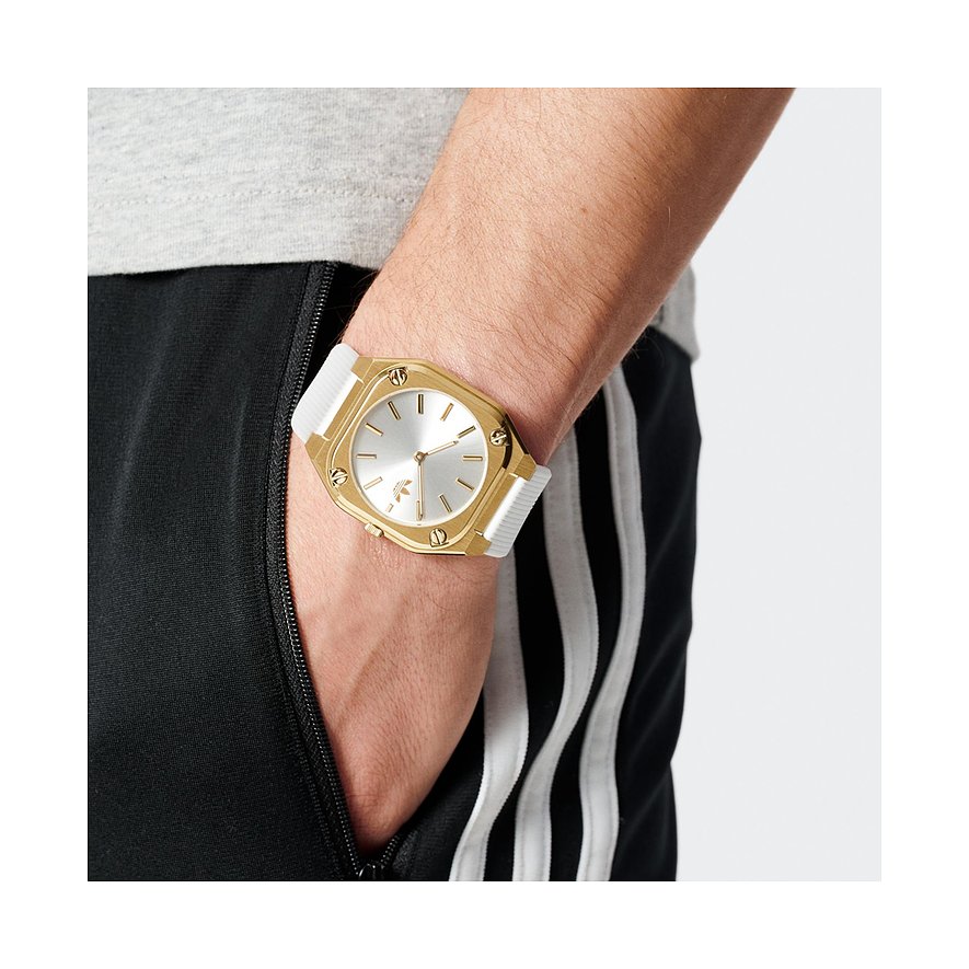 Montre unisexe Adidas avec boîtier en acier inoxydable, cadran argenté et bracelet blanc.