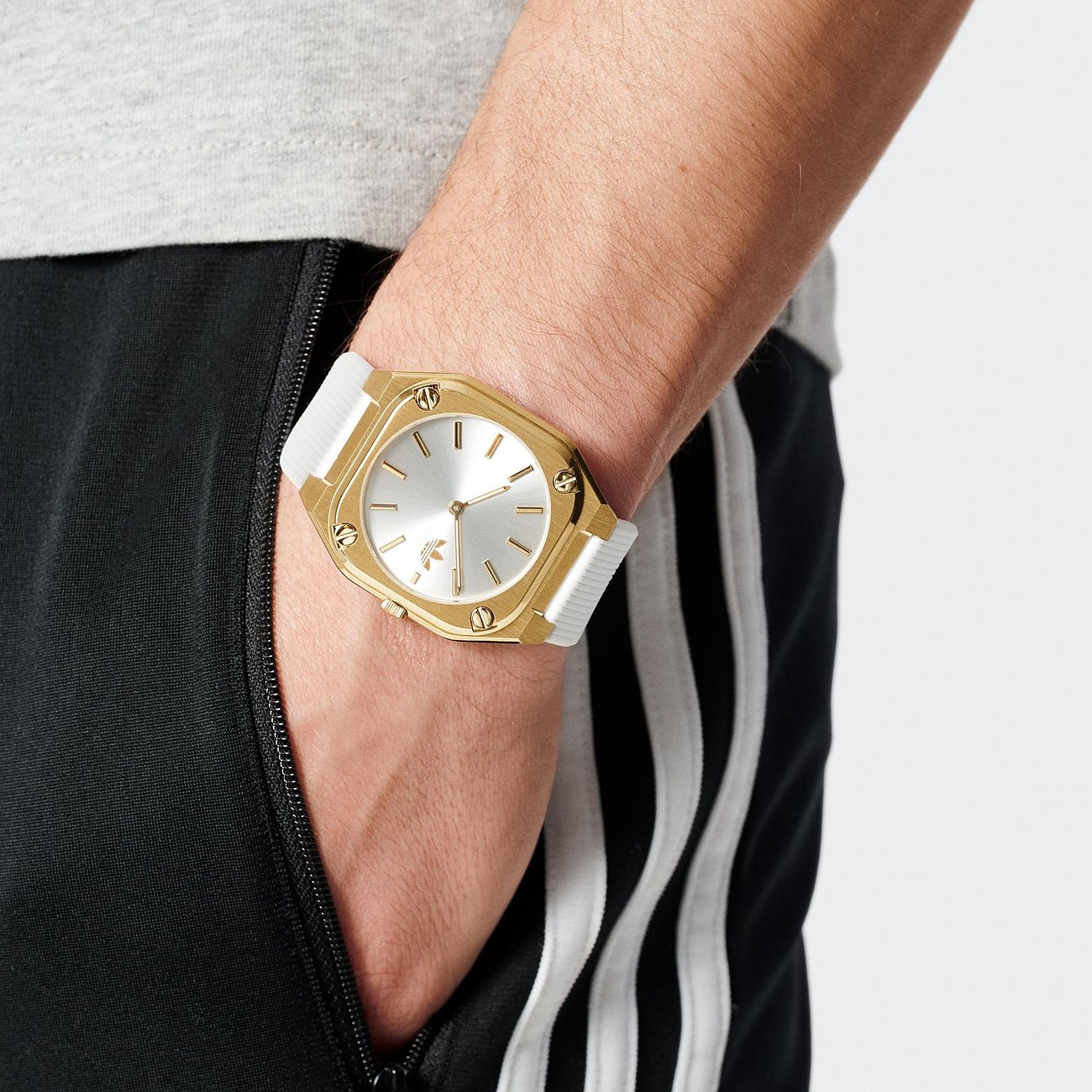 Montre unisexe Adidas avec boîtier en acier inoxydable, cadran argenté et bracelet blanc.