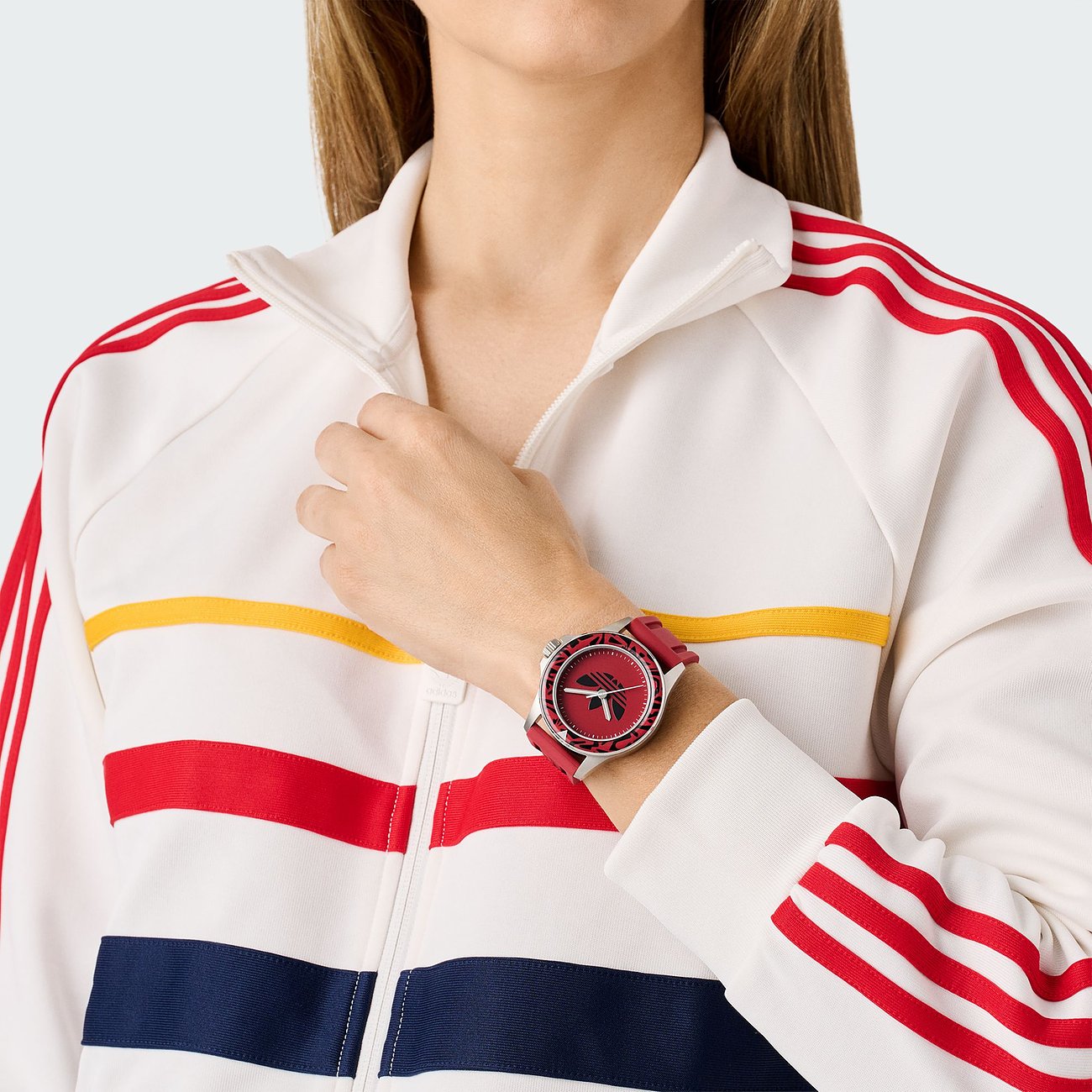 Adidas Unisexuhr mit Edelstahlgehäuse, analoger Anzeige und rotem Zifferblatt.