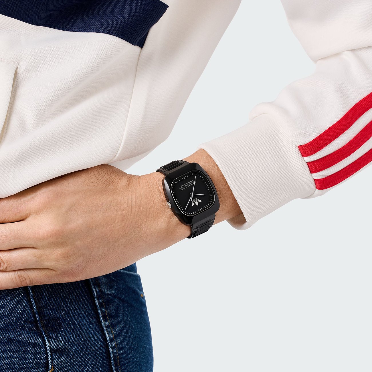 Montre unisexe Adidas avec boîtier en céramique, cadran noir et affichage analogique.
