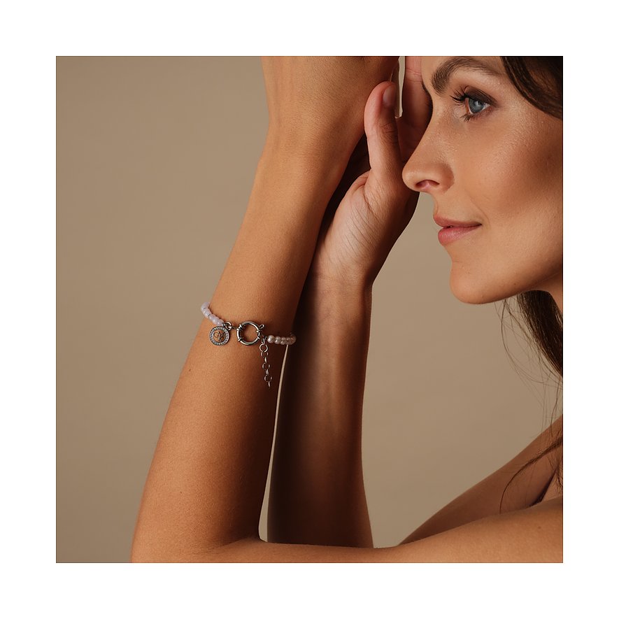 Un bracelet Guido Maria Kretschmer en acier inoxydable avec perles et cristaux est visible au poignet d'une femme.