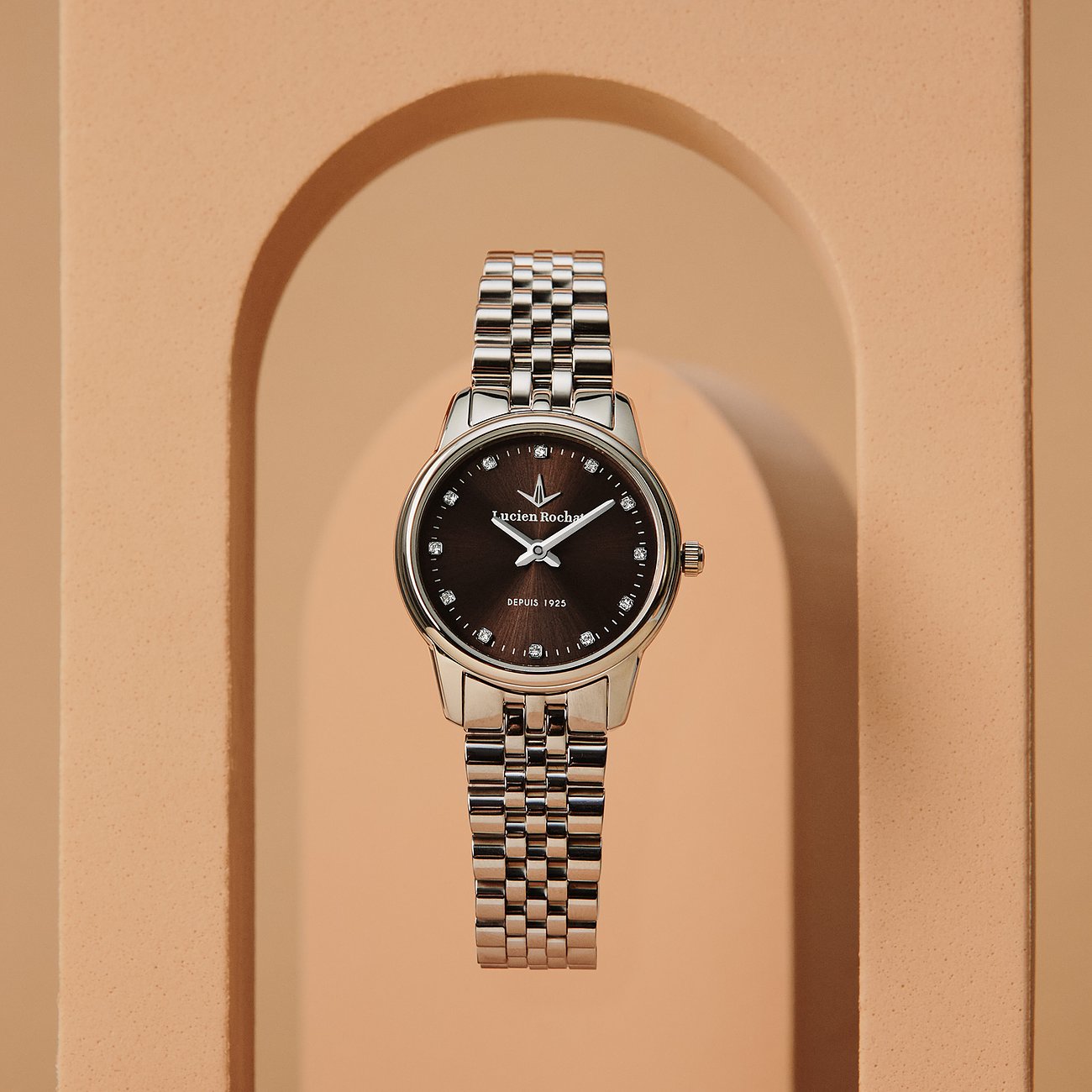 La montre femme Lucien Rochat en acier inoxydable avec diamants présente un cadran marron et un bracelet à maillons argenté.