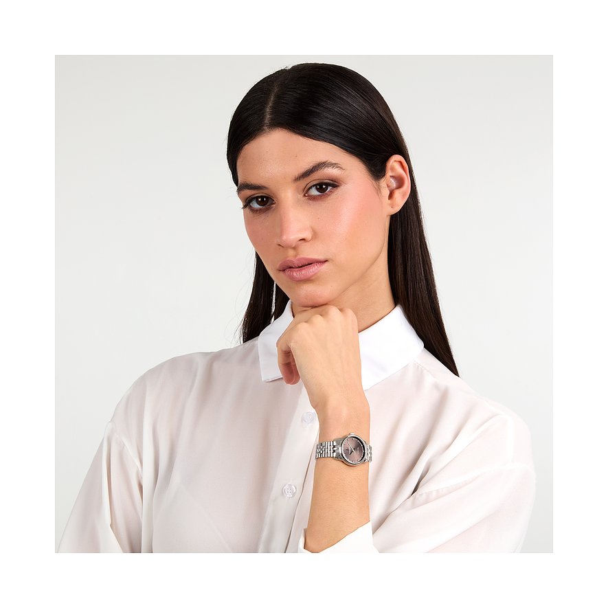 Un mannequin porte une montre femme Lucien Rochat en acier inoxydable avec diamants et cadran foncé.