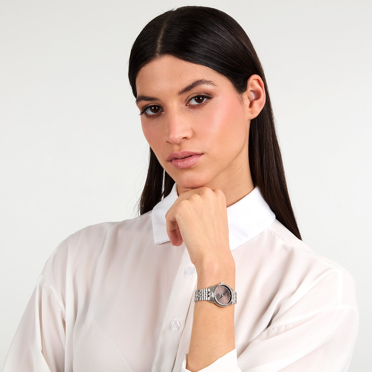 Un mannequin porte une montre femme Lucien Rochat en acier inoxydable avec diamants et cadran foncé.