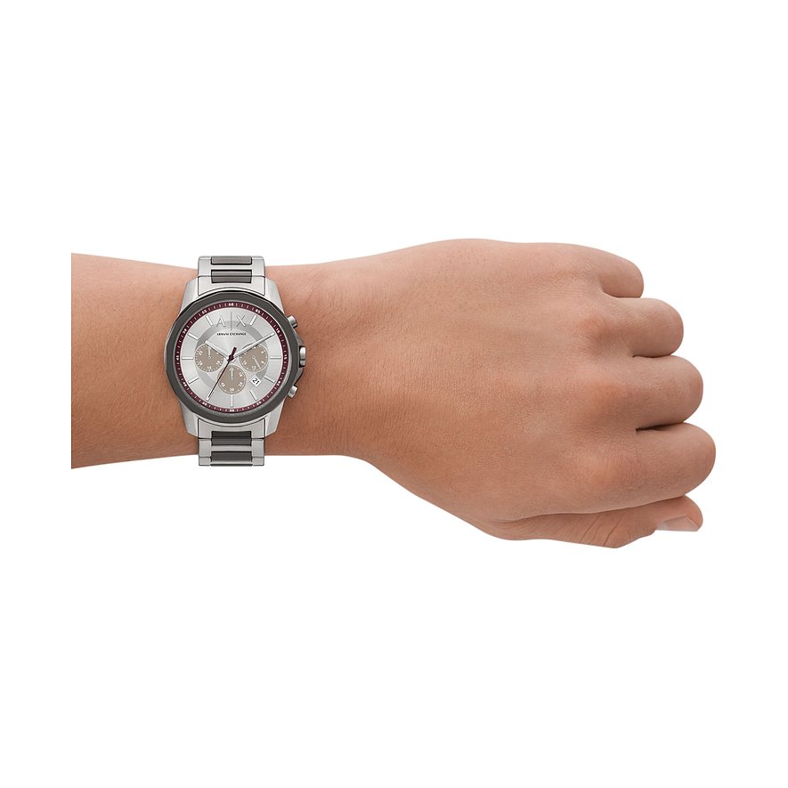 Die Armani Exchange Herrenuhr aus Edelstahl wird am Handgelenk eines Models getragen und zeigt das silberne Zifferblatt.