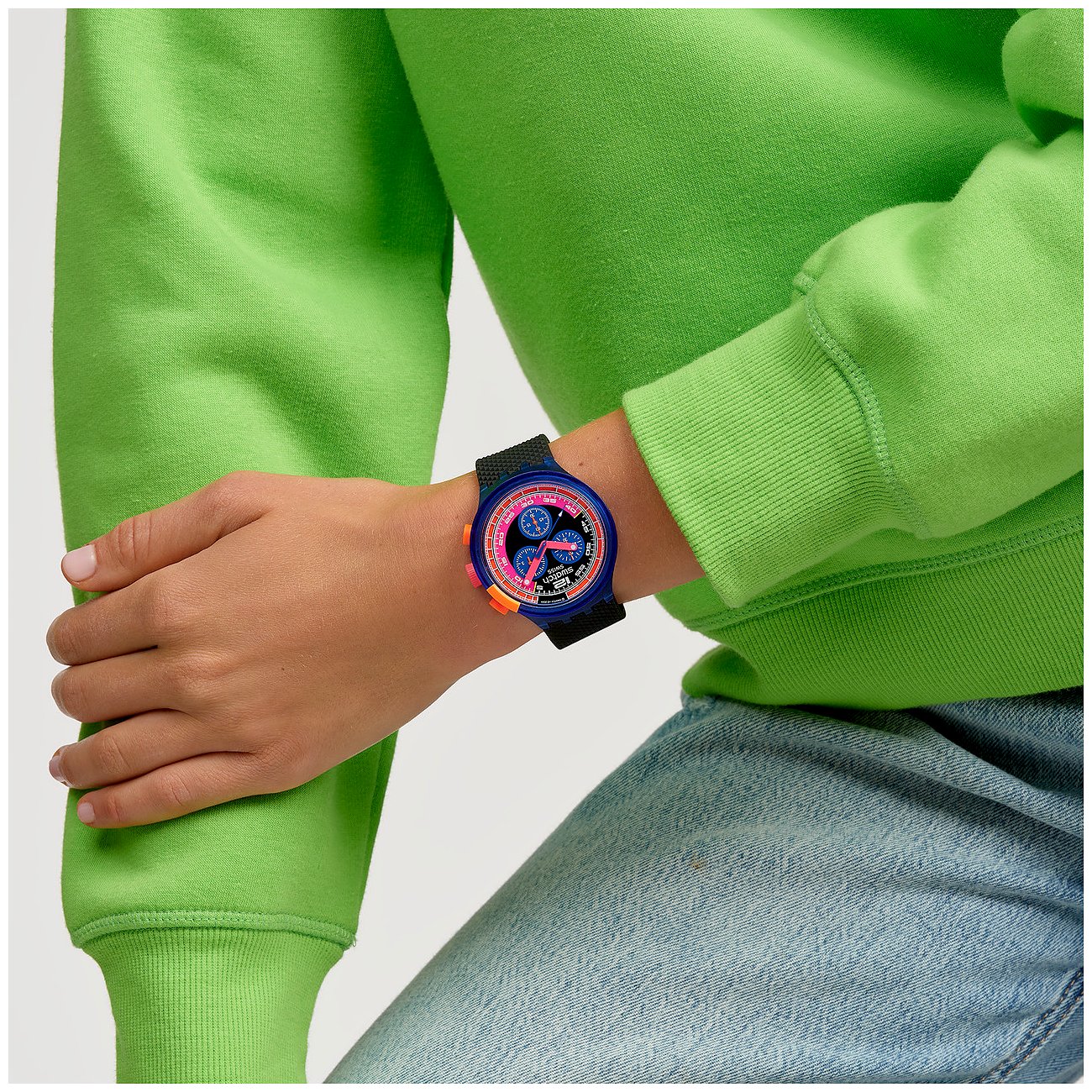 Swatch Unisexuhr mit Kunststoffgehäuse, analoger Anzeige und bunter Lünette.
