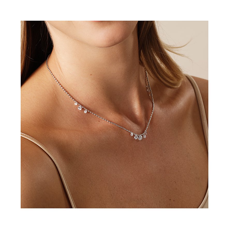 Nahaufnahme einer Frau, die eine CHRIST Halskette aus recyceltem Silber mit funkelnden Zirkonia-Farbsteinen trägt.