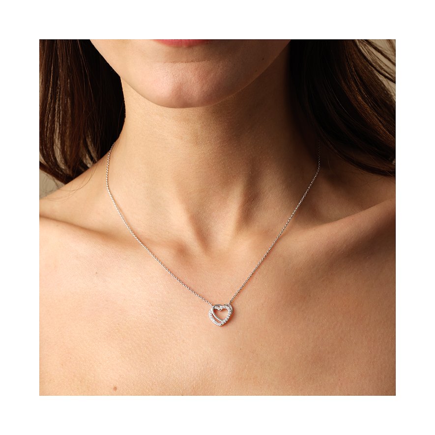Une femme porte un collier cœur FAVS en argent 925 avec des pierres de zircon de couleur comme parure de cou.
