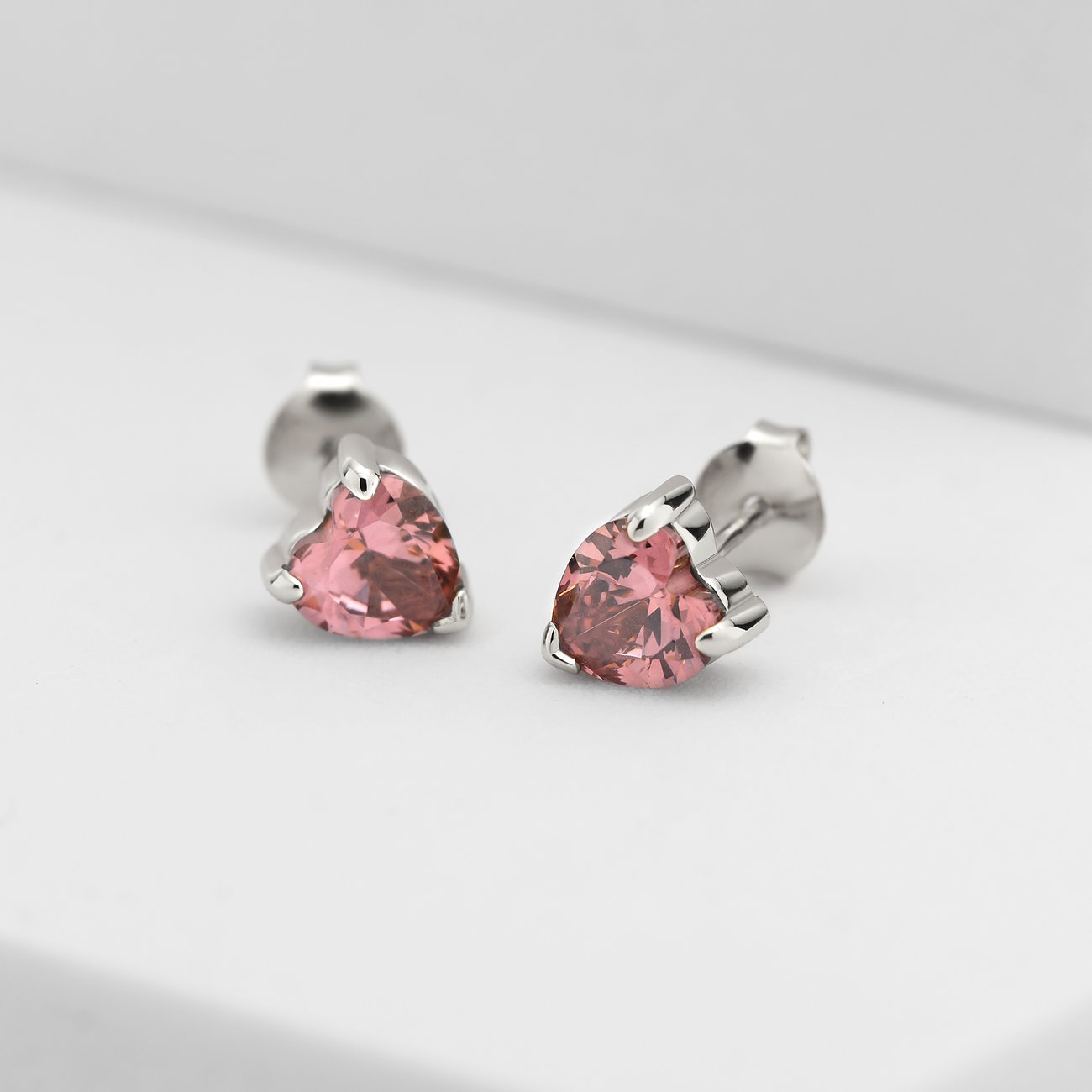 CHRIST Ohrstecker aus recyceltem 925er Silber mit herzförmigen rosa Zirkonia im Anschnitt, von vorne.